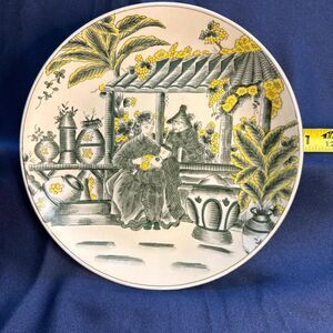 1970s Asian-inspired porcelain plate with yellow and green floral design 10 1/2”